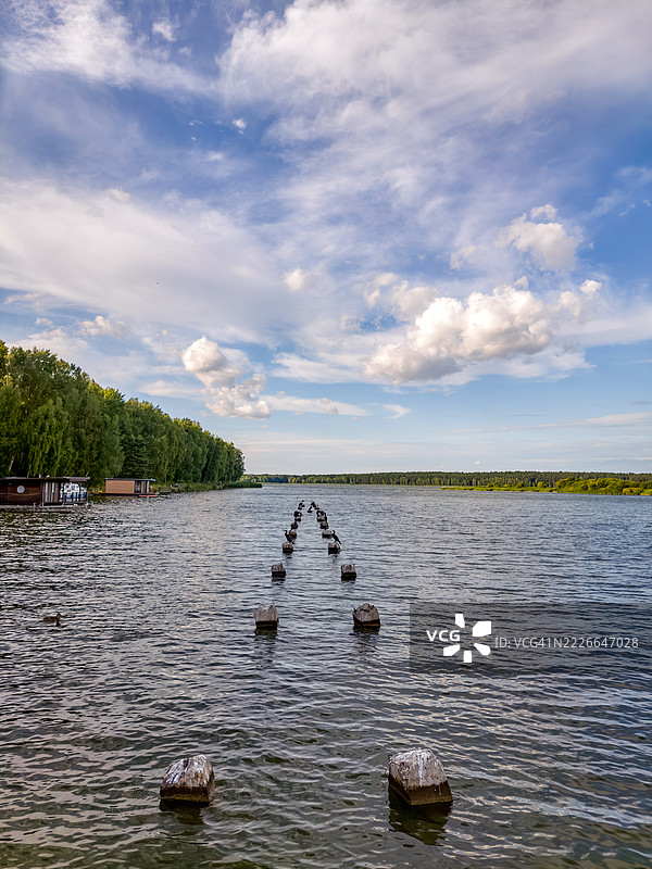 一排混凝土柱子伸入平静的湖面图片素材