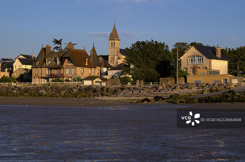 低潮时从海滩望向 Église Notre-Dame de Grandcamp-Maisy 教堂、村庄、格兰康梅西,傍晚光线,诺曼底,卡尔瓦多斯,法国图片素材
