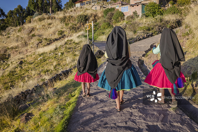 年轻女孩在秘鲁的的的喀喀湖塔基莱岛上手工纺羊毛图片素材