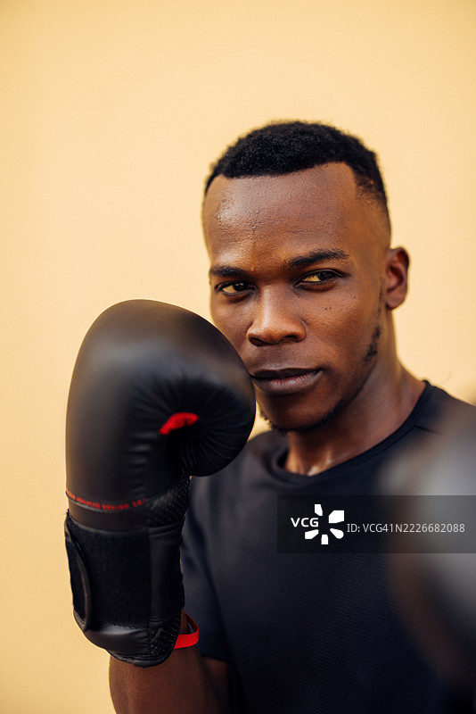 专注的年轻拳击手穿着专业装备，表情严肃地准备训练图片素材