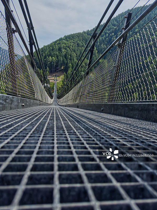 通往森林山脉的悬索桥，意大利萨伦蒂诺图片素材