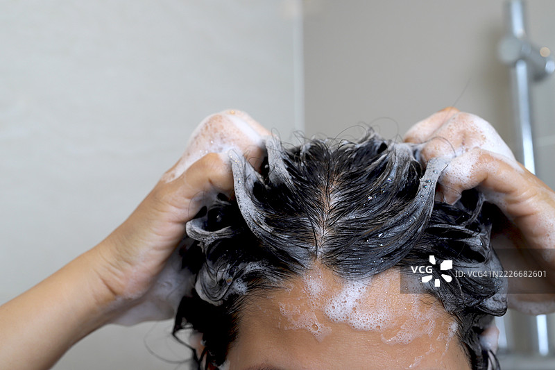 一名女性在泰国曼谷的浴室里洗澡并洗头。图片素材