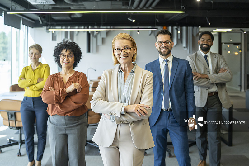 自信的商务团队在现代办公室微笑并交叉双臂图片素材