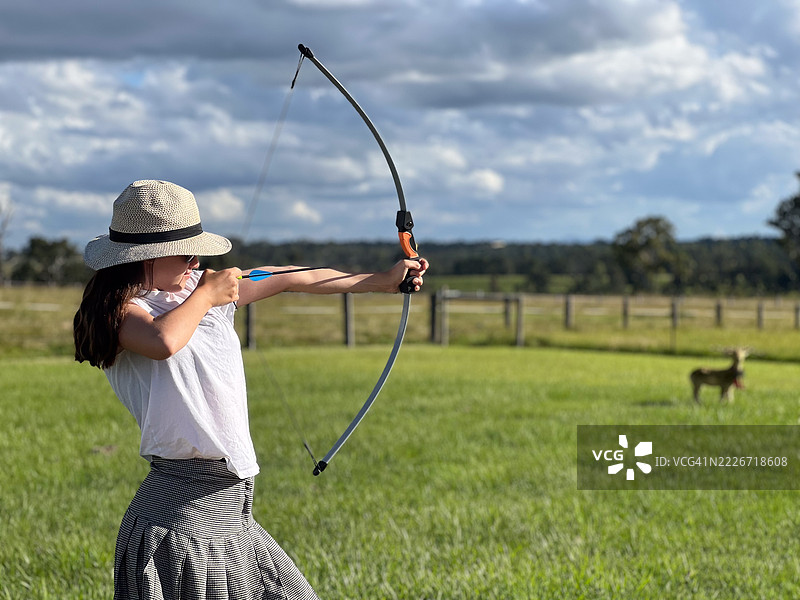青少年农女孩用弓箭射击靶子图片素材