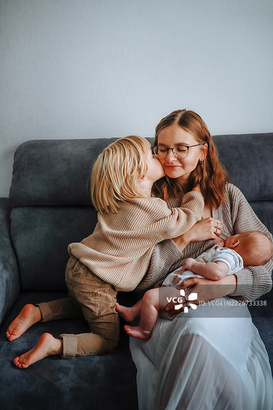 母亲的平衡：一边喂养一个孩子，一边照顾另一个孩子图片素材