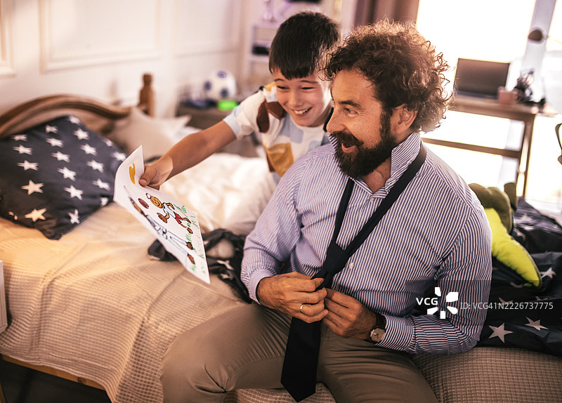 儿子自豪地展示他与爸爸一起打棒球的画作图片素材