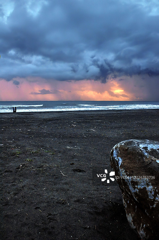 戏剧性的海景，波涛汹涌，暴风云密布，地平线上散发着温暖的光辉。图片素材