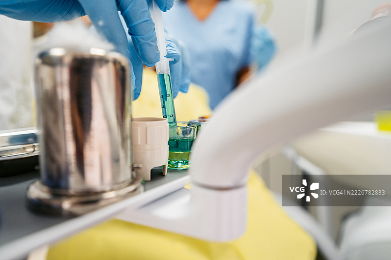 年轻男牙医在牙科办公室准备注射器中的药物图片素材