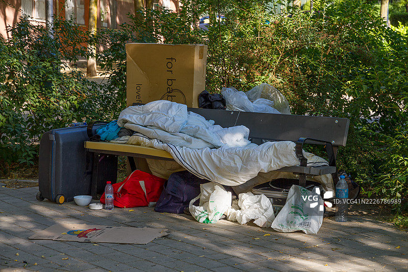 无家可归者在街头长椅上的个人物品图片素材