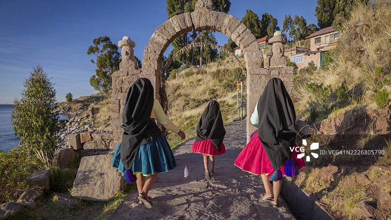 年轻女孩在秘鲁的的的喀喀湖塔基莱岛上手工纺羊毛图片素材