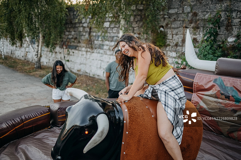 人们在城市里户外骑机械公牛玩得很开心图片素材