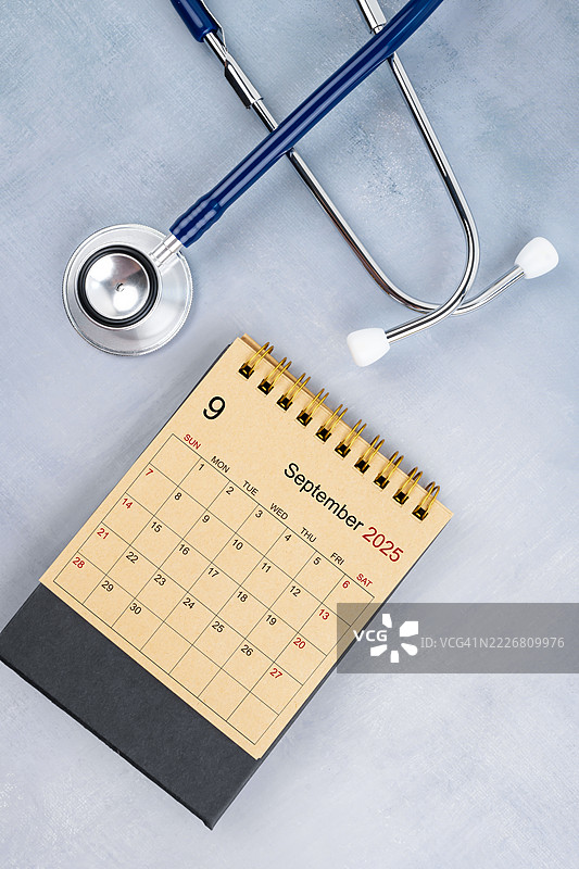 2025年9月桌面日历，手工棕色纸质日历与听诊器，医生预约概念。图片素材