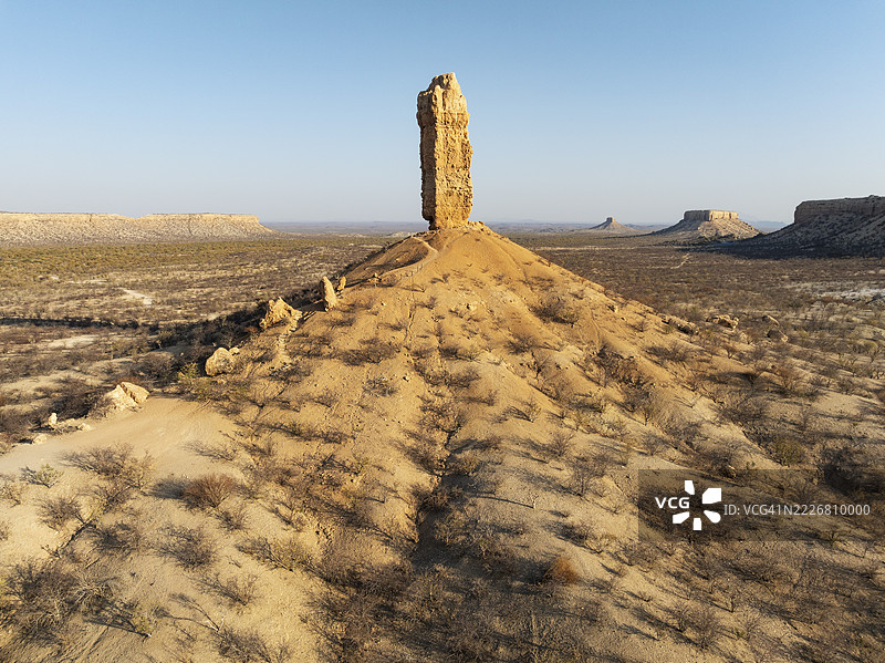 维根克利普（岩石手指）和乌加布谷地的梯田被荆棘灌木和莫帕尼（莫帕尼树）草原环绕。鸟瞰图。无人机拍摄。纳米比亚达马拉兰。图片素材