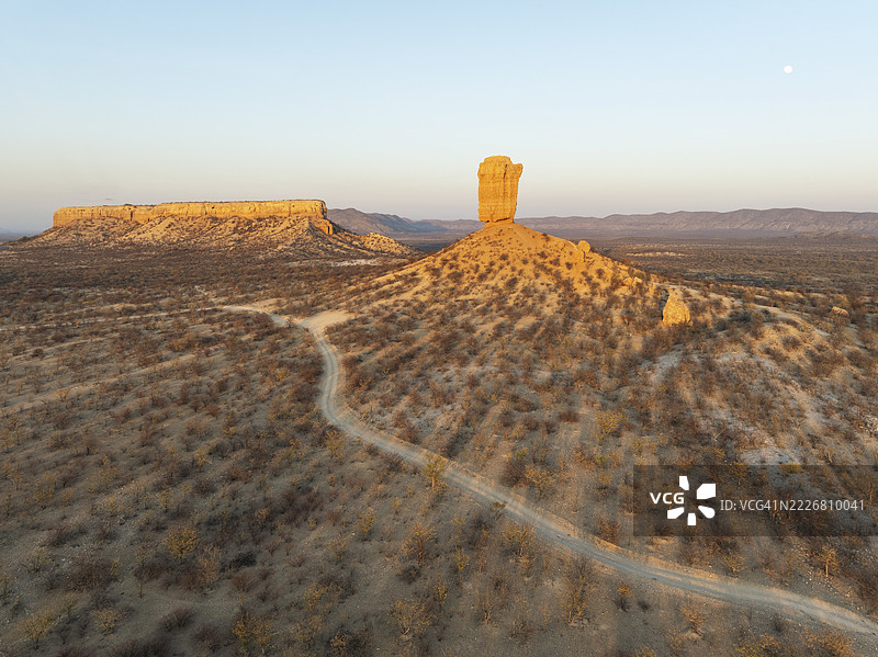 维根克利普（岩石手指）和乌加布谷地的梯田被荆棘灌木和莫帕尼（莫帕尼树）草原环绕。鸟瞰图。无人机拍摄。纳米比亚达马拉兰。图片素材