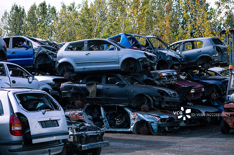 被自然环绕的废弃汽车堆放在废品回收场图片素材