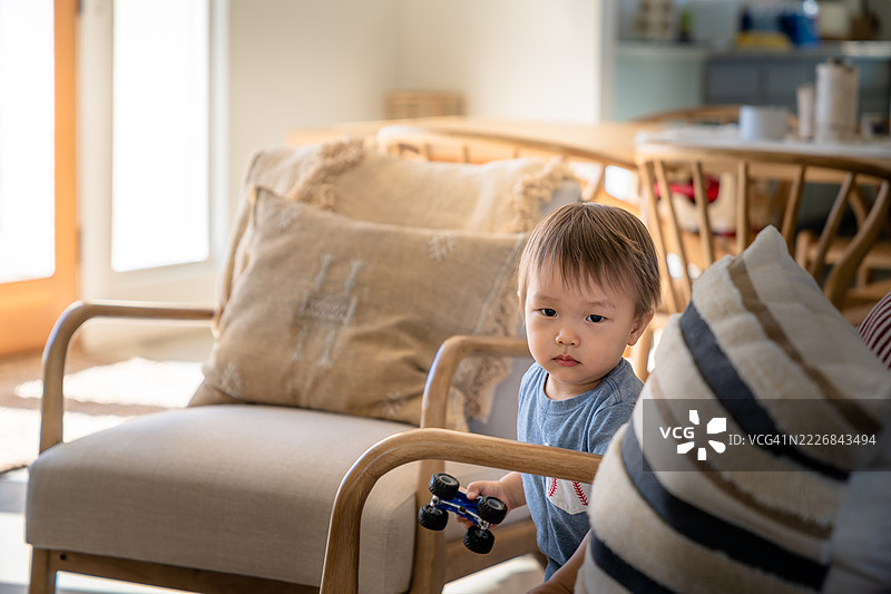 幼儿在温暖的晨光中室内玩玩具车，位于加利福尼亚州二十九棕榈市，美国图片素材