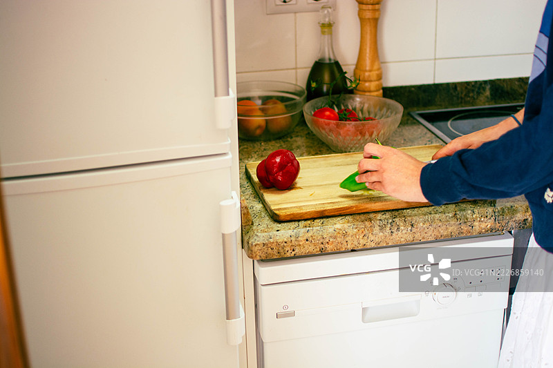 女性在现代厨房中切菜图片素材