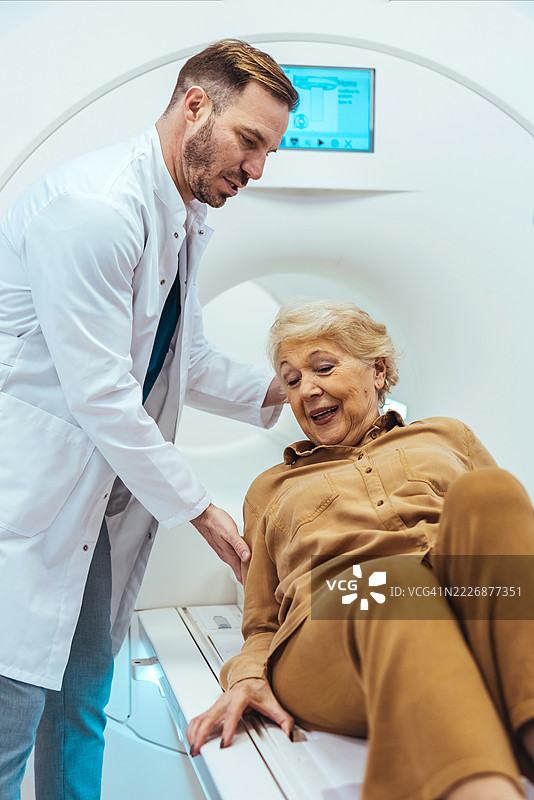 医生在现代诊所协助老年女性进行医学影像检查图片素材