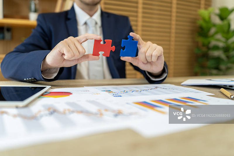 商人将两块拼图与财务图表结合在一起图片素材