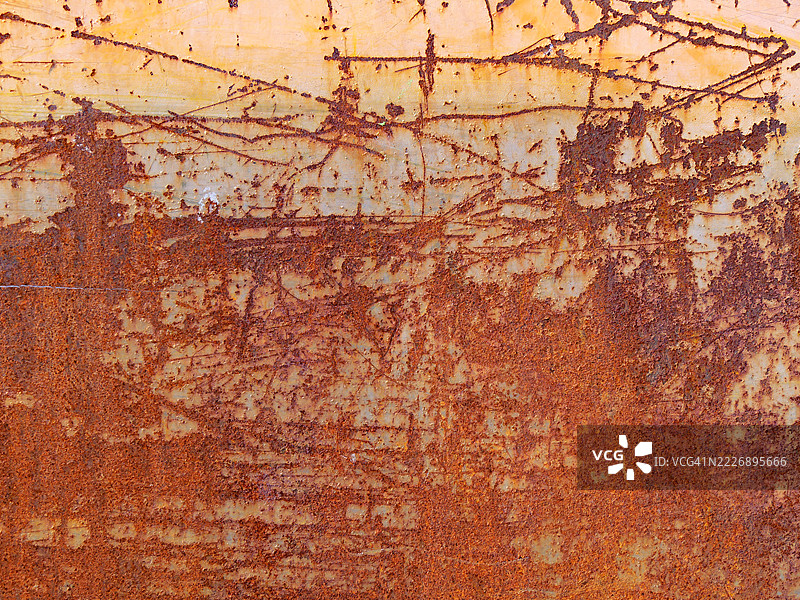生锈的金属板特写,涂成橙色并有划痕。粗糙的纹理。自然的铜绿和色彩。阳光。法国上萨瓦省埃维昂-莱-班。全画幅 4:3图片素材