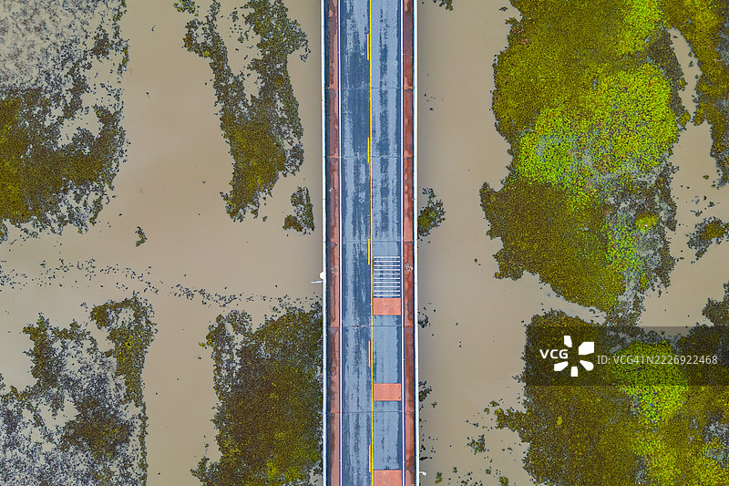 从上方俯瞰泰国宋卡湖上的桥梁上的汽车。图片素材