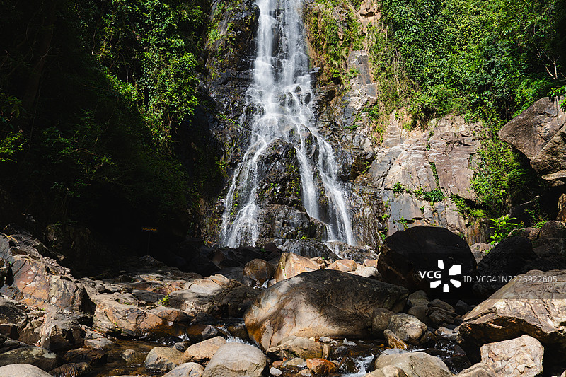 在泰国那空西塔马拉特，苏南塔瀑布在雨季优雅地从分层的石灰岩悬崖上倾泻而下，四周被郁郁葱葱的热带森林环绕，清澈的水流入宁静的天然泳池。图片素材