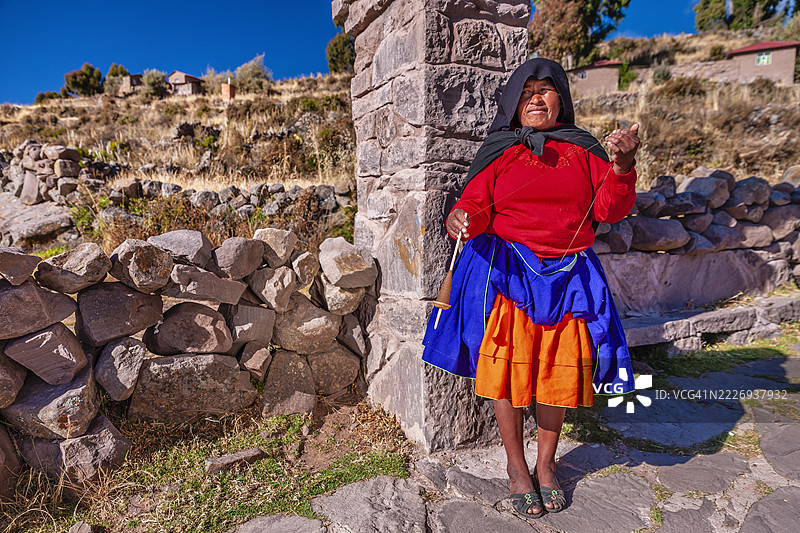 在秘鲁塔基莱岛上，女人用手纺羊毛。图片素材