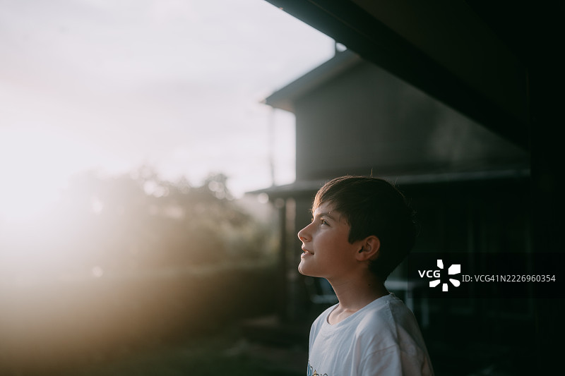 年轻男孩在阳台上欣赏日落景色图片素材