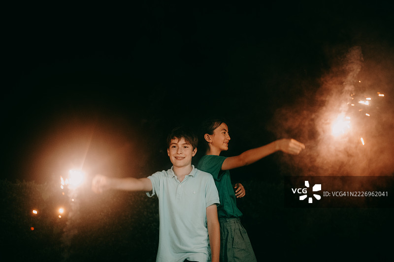 孩子们在夜晚享受烟花棒的乐趣图片素材