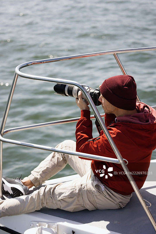 摄影师在船上用长焦镜头拍照图片素材