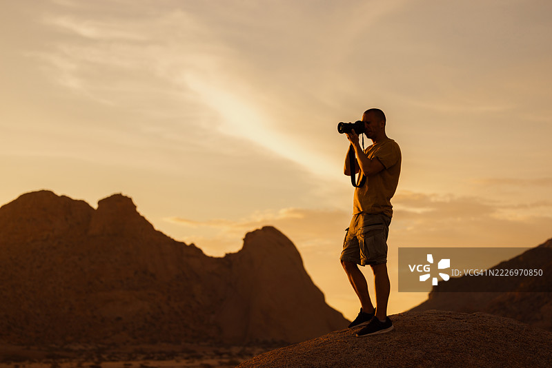 摄影师在纳米比亚的斯皮茨科普山日落时拍照图片素材