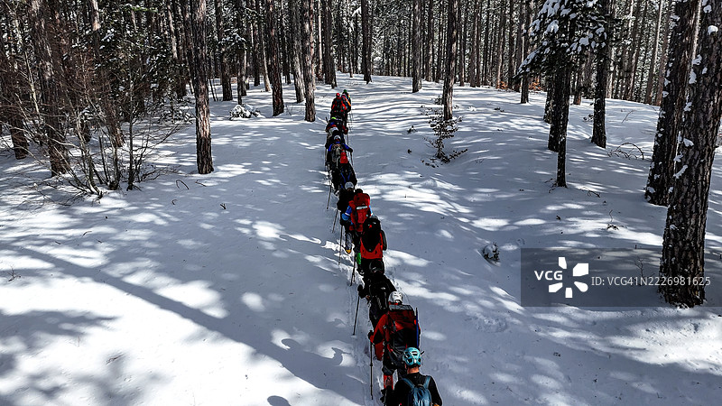 乌鲁达山（Uludağ Mountain），土耳其布尔萨（Bursa），冬季冒险，登山者在深雪中穿越森林坡道的雪地小径，户外活动与自然探索的照片。图片素材