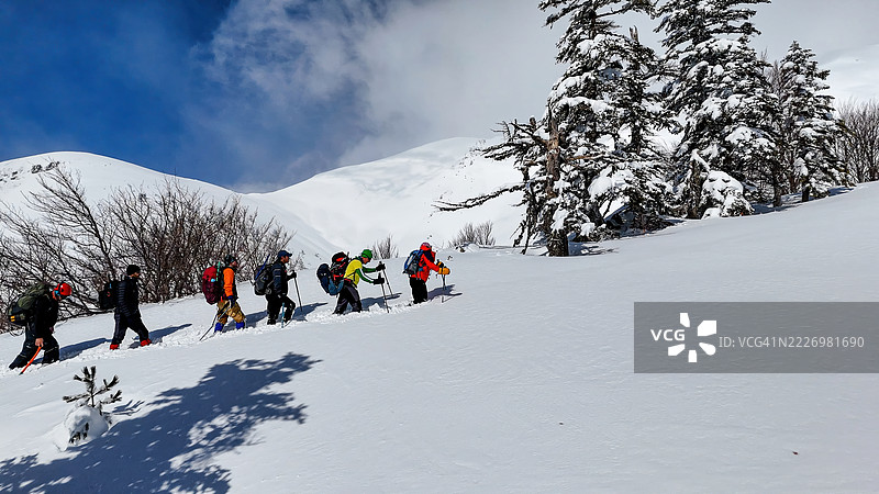 乌鲁达山(Uludağ Mountain),土耳其布尔萨(Bursa)冬季冒险,登山者在深雪中徒步穿越被森林覆盖的山坡,户外活动与自然探索的照片。图片素材