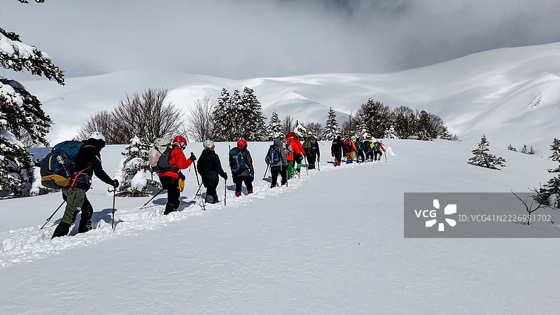 乌鲁达山（Uludağ Mountain），土耳其布尔萨（Bursa），冬季冒险，登山者在深雪中徒步穿越被森林覆盖的山坡，户外活动与自然探索的照片。图片素材