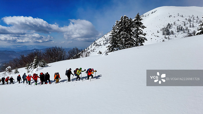 乌鲁达山(Uludağ Mountain),土耳其布尔萨(Bursa),冬季冒险,登山者在深雪中穿越森林坡道,户外活动与自然探索的照片。图片素材