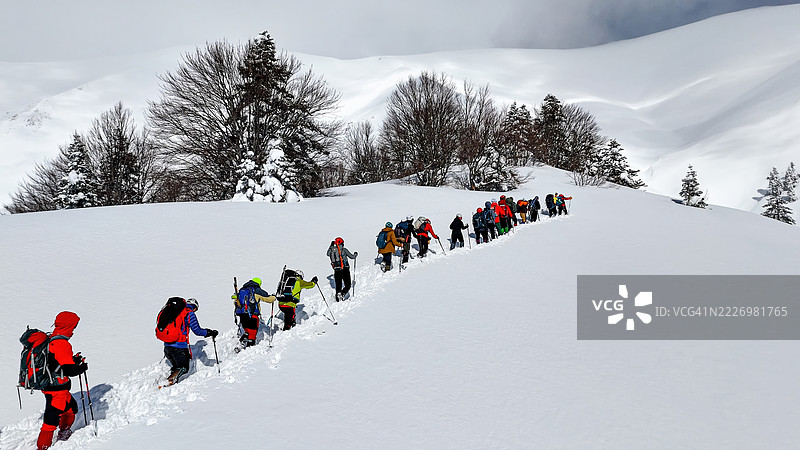 乌鲁达山（Uludağ Mountain），土耳其布尔萨（Bursa）冬季冒险，登山者在深雪中穿越森林坡道的雪道，户外活动与自然探索的照片。图片素材