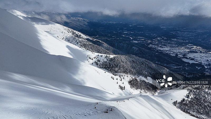 土耳其布尔萨乌鲁达山的雪覆盖森林坡和山峰的鸟瞰图，冬季自然景观，伴有戏剧性的云彩和阿尔卑斯风光，季节性自然与旅游目的地概念图片素材
