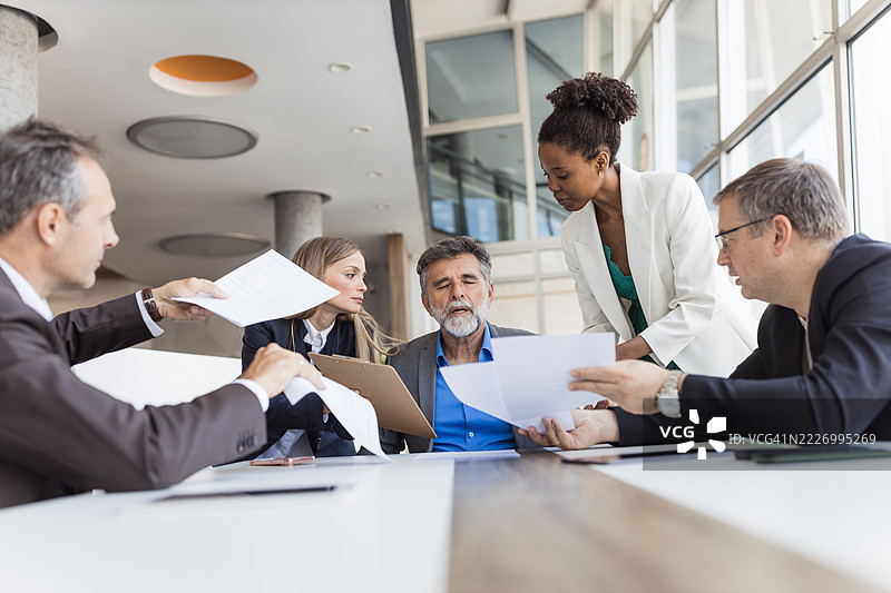 商务团队在办公室会议期间交换文件图片素材