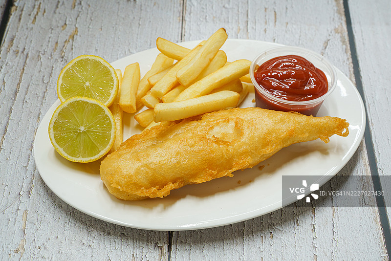 酥脆的炸鱼和薯条配番茄酱。图片素材