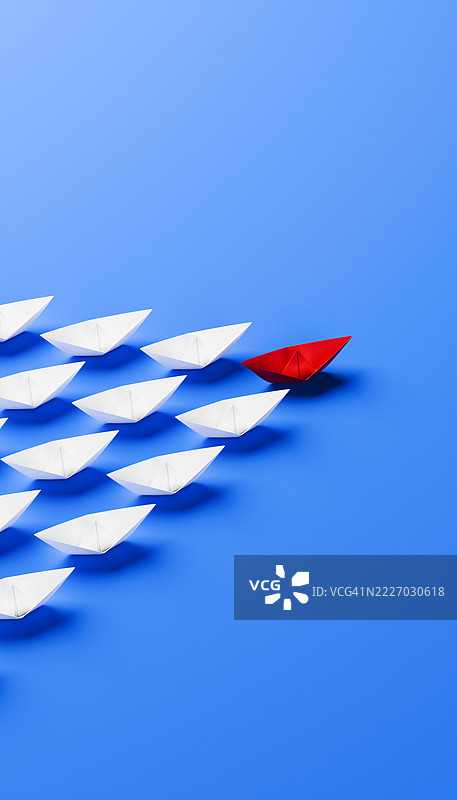 战略领导与方向的象征：蓝色背景上的红色折纸船图片素材