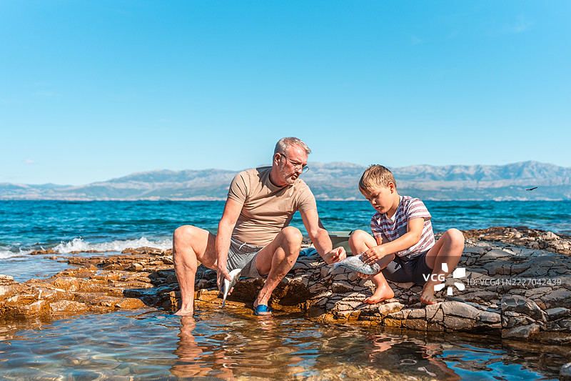 白人祖父与男孩在阳光明媚的海岸上建立亲密关系图片素材