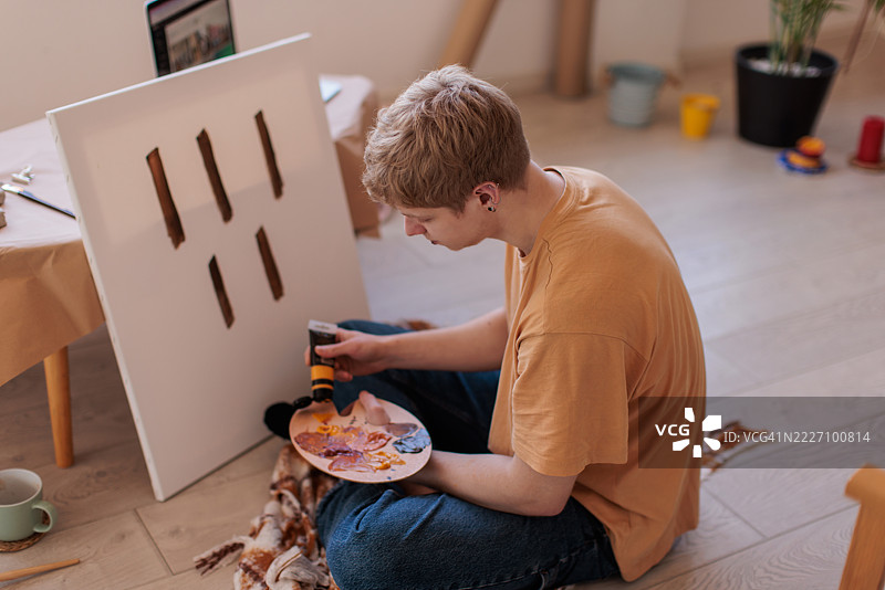 年轻艺术家专注于调色和绘画图片素材