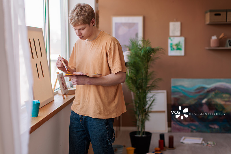 充满激情的艺术家在凌乱的家庭工作室中作画图片素材