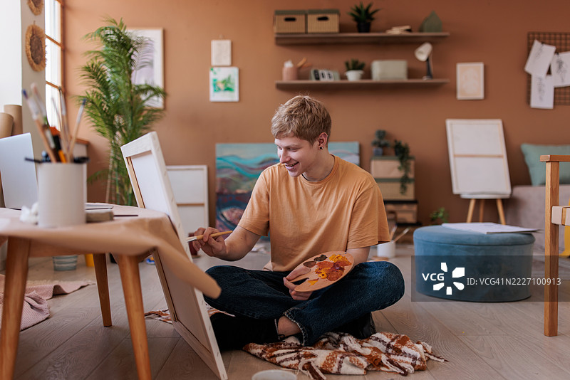 充满激情的艺术家在凌乱的家庭工作室中作画图片素材