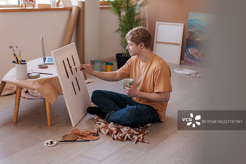 年轻画家的客厅变成了艺术工作室图片素材