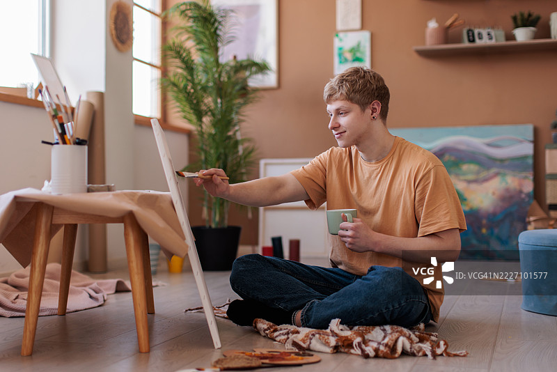 年轻画家的客厅变成了艺术工作室图片素材