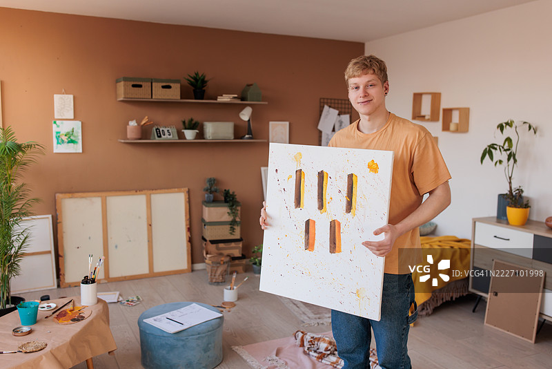 自豪的画家在家中工作室里展示作品图片素材