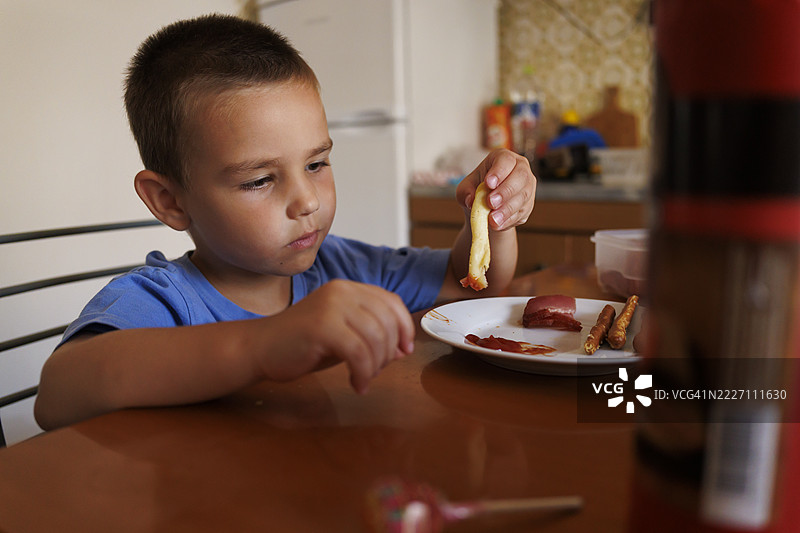 可爱的小男孩在家吃早餐图片素材