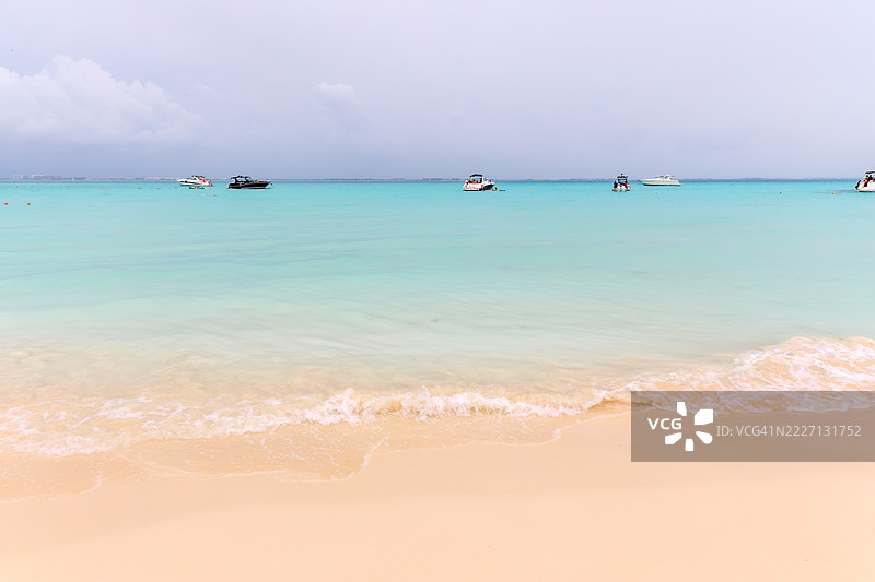 在伊斯拉穆赫雷斯岛的北滩，阴云密布的天空下，美丽的白色沙滩和碧蓝的海洋相映成趣。图片素材