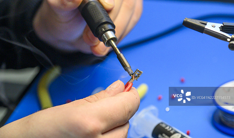 技术员在电缆上焊接电子元件图片素材